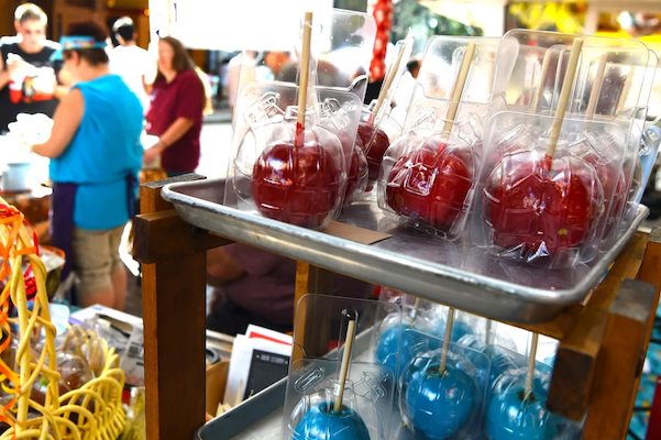 Rows of colorful candy apples lined up for sale!