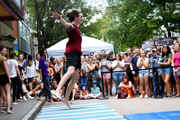 A performer putting on a show as dozens of spectators gather!