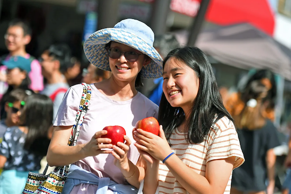 A mother and daughter posing with their apples together!