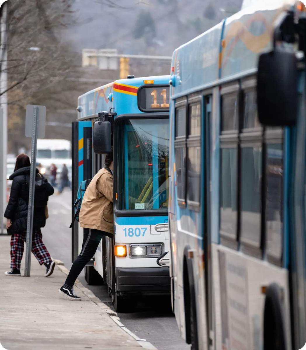 A young man stepping onto a TCAT bus in Ithaca!